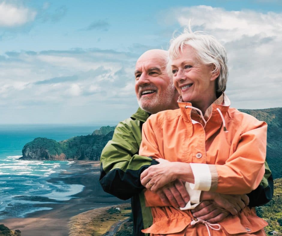 A couple smiling together above a West Coast beach